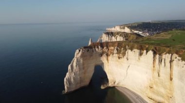 Etretat 'ın nefes kesen uçurumlarını keşfedin çarpıcı bir günbatımında, altın gökyüzünün sakin okyanus dalgalarıyla buluştuğu yerde. Doğa güzelliği her karede saygı ve sükunet uyandırır..