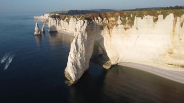 Etretat 'ın nefes kesen uçurumlarına hayret ediyorum. Yumuşak sabah ışığı el değmemiş denizin üzerine altın bir parıltı saçıyor. Bu ikonik Fransız sahil şeridinin barışçıl güzelliğini tecrübe edin..