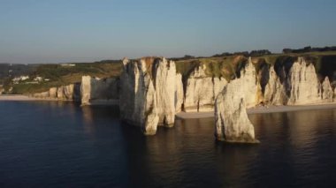 Güneş batarken Etretat 'ın nefes kesen güzelliğine tanık olun. Sükunet sulara altın renkler saçan ve Fransa' daki bu sahil taşının cazibesini gözler önüne seren uçurumlar..