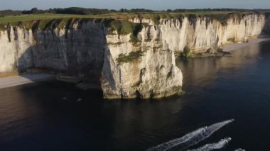 Güneş ikonik uçurumların üzerinde batarken Etretat 'ın nefes kesici güzelliğini hissedin. Kayakçılar, görkemli tebeşir oluşumları ve sakin sularla çevrili kıyı şeridi boyunca huzur içinde süzülüyor..