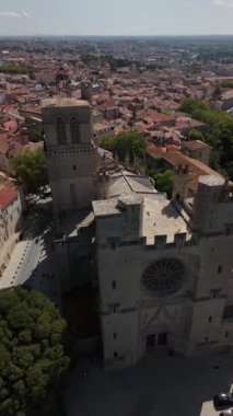 Kamera antik mimarisinin yanından geçerken Beziers 'in çarpıcı manzarasını keşfedin. Tarihi yapıların güzelliğini ve bu büyüleyici Fransız şehrinin canlı çatılarını gözler önüne seriyor..