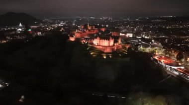 Görkemli Edinburgh Şatosu gece gökyüzüne karşı aydınlanarak büyük mimarisini gözler önüne seriyor. Parlak ışıklar bu ikonik simgenin zengin tarihini ve güzelliğini yansıtıyor..