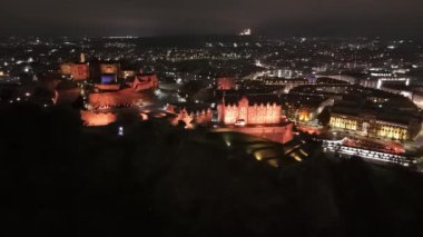 Edinburgh Şatosu 'nun göz kamaştırıcı güzelliğini tecrübe edin. Gece gökyüzüne karşı görkemli bir şekilde parlıyor. Canlı şehre tepeden bakıyor. Tarihi mekan büyüleyici ışıklarıyla büyüleniyor..