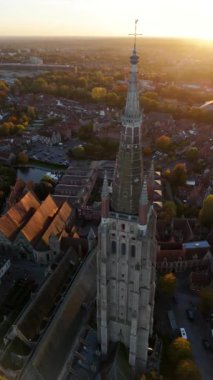 Güneş batarken, Bruges 'deki Meryem Ana' nın büyüleyici kilisesinin üzerine altın rengi dökülüyor..
