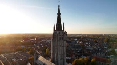 Güneş batarken Lady Bruges Kilisesi 'nin nefes kesen manzarasını tecrübe edin. Görkemli mimarisine ve çevresine altın ışık saçarak büyülü bir atmosfer yaratın..