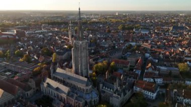 Bruges 'deki Leydimizin Kilisesi' nin nefes kesici manzarasını tecrübe edin, altın bir günbatımı parıltısının altında antik sokaklar ve mimari mucizelerle çevrili, zengin tarihi gözler önüne seriyor..