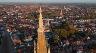 Leydimiz Kilisesi 'ne çıkarken Bruges' ün göz kamaştırıcı manzaralarını keşfedin. Gün batımında bu tarihi şehrin ikonik mimarisini, canlı çatılarını ve dingin cazibesini tecrübe edin..