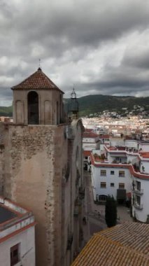 Tossa de Mar 'da dolaşın ve çarpıcı mimari ve panoramik manzaralara hayran olun. Büyüleyici binaların üzerinde yükselen antik kuleler, yemyeşil dağlar ve bulutlu gökyüzü tarafından çerçevelenir..