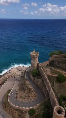 Tossa de Mar 'ın masmavi sularına bakan büyüleyici kıyı kulesini keşfedin. Dalgalar kıyı şeridine çarparken nefes kesici görüntülere hayret ederek sakin bir atmosfer yaratıyor..