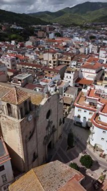 Tossa de Mar 'ın cazibesini keşfedin, antik sokaklarında dolaşırken, çarpıcı manzaralar ve dramatik bir gökyüzü altında, çatıların ve çevreleyen manzaraların tadını çıkarın..