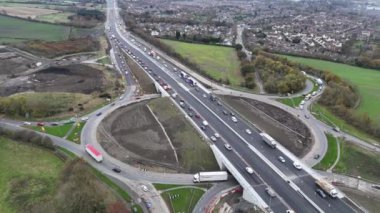 Yoğun trafik kavşağı tıkayarak yol çalışması her zamanki akışı bozuyor. İnşaat ekipleri yakındaki otoyolda özenle çalışırken, araçlar dolambaçlı yollarda yol alıyorlar..