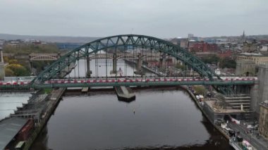 Newcastle Tyne Köprüsü 'nün göz kamaştırıcı mimarisine tanık olun bulutlu bir sonbahar gününün arka planına karşı kurulmuştur. Atmosfer nehir kıyısındaki hareketlilikle dolu..