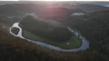 Botassart 'ın yemyeşil manzarasında süzülen nehrin nefes kesici kıvrımlarına tanık olun. Bu huzurlu an, huzurlu bir günbatımında güzelliği yakalar, huzuru ve yansımayı davet eder..