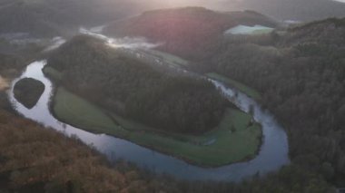 Le Tombeau du Geant 'ın baş döndürücü doğal kıvrımlarına tanık olun. Sabah güneşi yumuşak parıltısını yemyeşil araziye saçıyor. Huzurlu nehir ormanda dans eder, nefes kesici bir manzara yaratır..