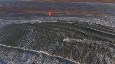 Yetenekli sürücüler okyanusun üzerinde süzülürken güçlü dalgalarda gezinirken uçurtma sörfünün heyecanına tanık olun. Güzel kumlu kıyı şeridinin ve güneşin altında dans eden canlı uçurtmaların tadını çıkar..