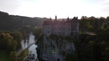Majestic Walzin Şatosu Meuse Nehri 'ne gururla bakıyor. Etrafı yemyeşil yemyeşil. Gün batımında büyüleyici manzarayı deneyimlemek, karmaşık mimari ayrıntıları ortaya çıkarır..