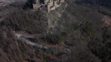 Hechingen yakınlarındaki Hohenzollern Dağı 'na tünemiş olan Hohenzollern Şatosu, zengin Alman tarihi ve doğal güzellikleri vurgulayarak dolambaçlı yollar ve ormanlık tepelerin çarpıcı manzarasını sunuyor..