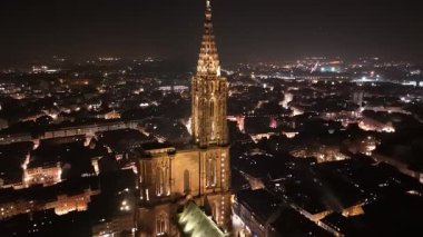 Geceleri Strasbourg Katedrali 'nin büyüleyici güzelliğini görün. Muhteşem mimari karanlık gökyüzüne karşı parlıyor, aşağıdaki canlı şehir ışıklarını sergiliyor ve büyülü bir atmosfer yaratıyor..