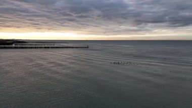 Şafakta yumuşak dalgaların kıyıya vurması gibi, Zeeland kıyılarının dingin güzelliğini hissedin. Ördekler sakin Kuzey Denizi 'nde bulutlardan oluşan bir battaniyenin altında huzur içinde dolaşarak sakin bir an yaratırlar..