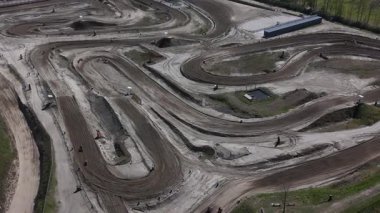 Motocross yarışçıları, Hollanda 'nın Axel kentindeki bir pistte şiddetle yarışıyorlar. Parlak güneşin altında, yarışın heyecanı havayı dolduruyor, yetenekli sürücüler ve heyecan verici manevralar sergiliyor..