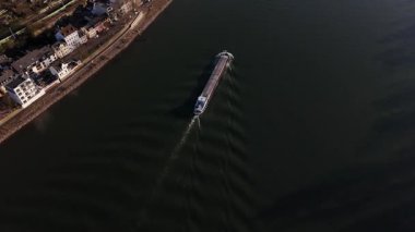 Huzurlu bir günbatımı, Ren nehrinin üzerine altın renkleri süzülürken bir mavna suyun içinde süzülüyor. Bu güzel Koblenz şehrini akşam ışığında görüntülüyor..