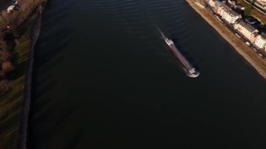 Güneş batarken Ren Nehri 'nde süzülen sakin bir mavnaya bir göz atın. Koblenz' in büyüleyici şehri üzerine ılık renkler döküyor. Doğanın ve şehir hayatının mükemmel bir anı..