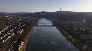 Ren Nehri üzerinde sakin bir günbatımı, suda yüzen sakin bir mavnayı vurguluyor. Çarpıcı Koblenz silüeti ufuk çizgisiyle pürüzsüz bir şekilde birleşiyor ve güzel bir akşam yaratıyor..