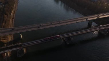 Alacakaranlık Koblenz 'in üzerine çökerken, köprü Ren Nehri üzerinde zarifçe kıvrılır, yerel trenler raylarında süzülerek, doğanın sakin bir karışımını ve bu güzel ortamda ulaşımı oluşturur..