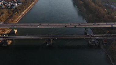 Alacakaranlık Koblenz 'e inerken, ikili köprüler Ren Nehri boyunca uzanarak tren ve araçların hareketlerini yakalıyor. Bu ikonik manzaranın huzur dolu güzelliğine tanık olun..
