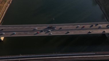 Trenler raylar boyunca süzülürken altın renkler Ren Nehri 'ni yansıtıyor. Sakin bir akşam trafiği köprünün üzerinden akarak Koblenz 'de sakin bir ortam yaratıyor..
