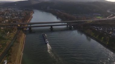 Güneş Koblenz üzerinde batarken, sakin bir mavna Ren nehrinin akan sularında yol alır. Akşam ışığının büyüleyici desenleri nehirden yansıyarak huzurlu bir ortam yaratıyor..