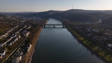 Alacakaranlık Koblenz 'in üzerine inerken Ren nehri yakındaki ışıkların yansımalarıyla parıldıyor..