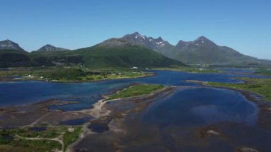 Yaz güneşinin altında canlı manzaralar canlandıkça Lofotens 'ın çarpıcı manzaralarını deneyimleyin. Kristal berrak sular, yemyeşil yemyeşil ve görkemli dağlar huzur dolu bir kaçış yaratır..