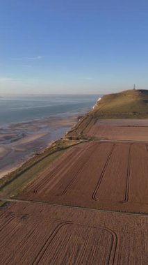 Altın saat boyunca Fransa 'nın kuzey kıyılarının nefes kesici manzarası. Yumuşak ışık, Normandy 'nin tarlalarının ve uçurumlarının güzelliğini artırıyor. Huzurlu ve resimsel bir manzara yaratıyor..