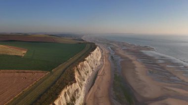 Cap Blanc Nez 'in altın ışıkta yüzen nefes kesici uçurumlarına tanık olun. Sakin güneşli hava, büyüleyici sahil manzarasını güzelleştirir. Manş Denizi boyunca zamansız cazibeyi gösterir..