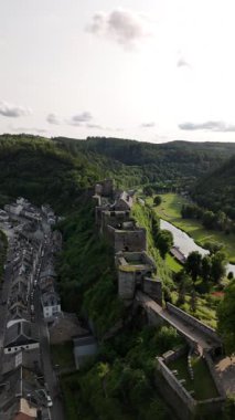 Belçika, Wallonia 'daki Bouillon Castel' in canlı yaz yapraklarıyla kaplanmış nefes kesici manzarasını deneyin. Kale güzel bir nehre ve aşağıdaki büyüleyici kasabaya bakıyor..