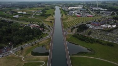 Yaz boyunca La Louviere 'deki Sart Canal Köprüsü' nün nefes kesici güzelliğini keşfedin. Bereketli yeşillik ve dingin sular pitoresk bir ortam yaratır, keşif ve rahatlamaya davetiye çıkarır..