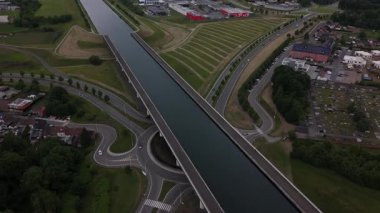 Güneşli bir yaz gününde Sart Kanal Köprüsü 'nün güzelliğini tecrübe edin. Huzurlu sular, canlı manzarayı yansıtırken yemyeşil alanlar, La Louviere 'deki bu mimari mucizeyi çevrelemektedir..