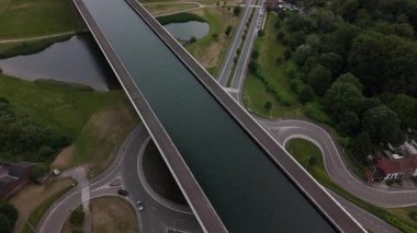 Büyüleyici Sart Kanal Köprüsü 'nün suların üzerinde süzülmesine tanık olun. Etrafı yemyeşil ve dolambaçlı yollarla çevrili. La Louviere yakınlarında yaz mevsiminin özünü yakalıyor..
