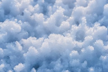 Snow as background, closeup view. Winter weather. Spring grainy blue snow background.