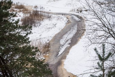 View to the small river flowing near the Baltic sea in winter in Saulkrasti in Latvia.