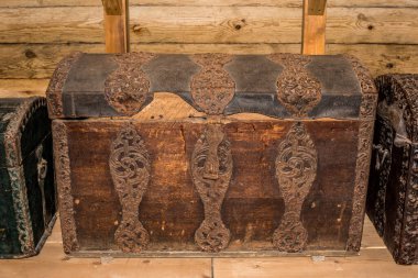 Tahta duvara yaslanmış eski ahşap sandık.