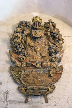 KURESSAARE Castle, Saaremaa, Estonia - 11 July, 2024: museum exhibits. Coat of arms on the wall in the old castle. clipart