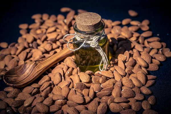 a pile of almonds and a glas with almond oil
