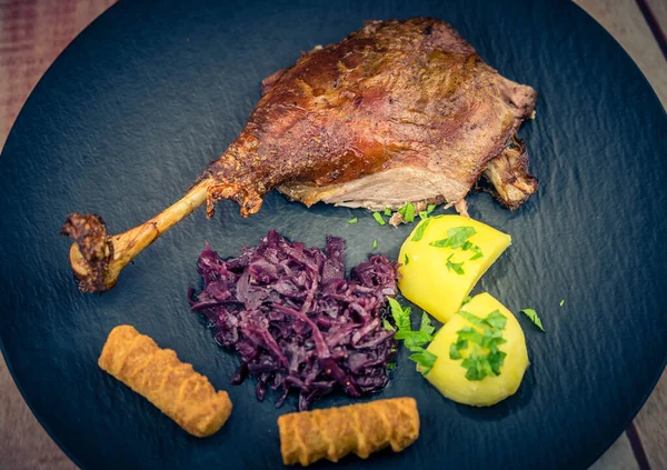 roasted goose with potatoes red cabbage and brown gravy
