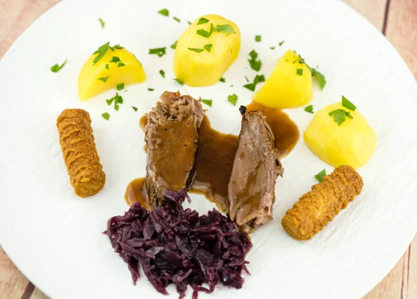 roasted goose with potatoes red cabbage and brown gravy