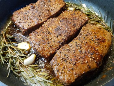 Kızartma tavasından taze kızarmış biftek ve lezzetli malzemeler.