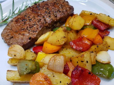 Kızartma tavasından taze kızarmış biftek ve lezzetli malzemeler.