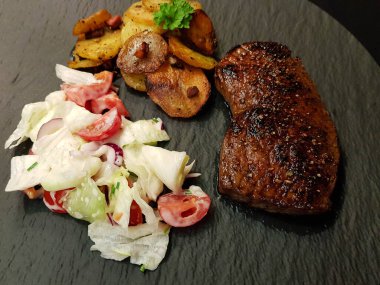 Kızartma tavasından taze kızarmış biftek ve lezzetli malzemeler.