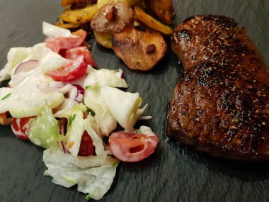 Kızartma tavasından taze kızarmış biftek ve lezzetli malzemeler.